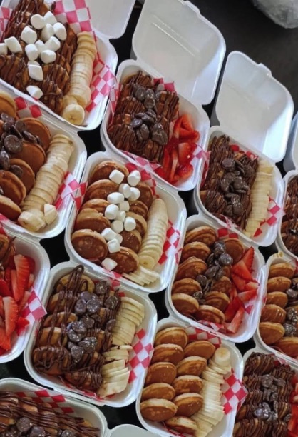 Bandejas de mini panqueques con chocolate, fresa y crema listas para servir